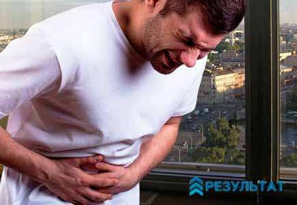 Мужчина держится за больной живот